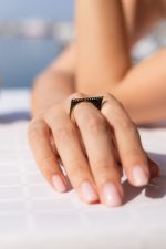 Inel Alizeee din aur 14K cu zirconii, model bar ring geometric, fotografiat din profil pe mână.