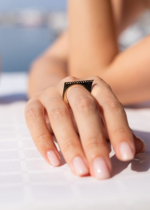 Inel Alizeee din aur 14K cu zirconii, model bar ring geometric, fotografiat din profil pe mână.